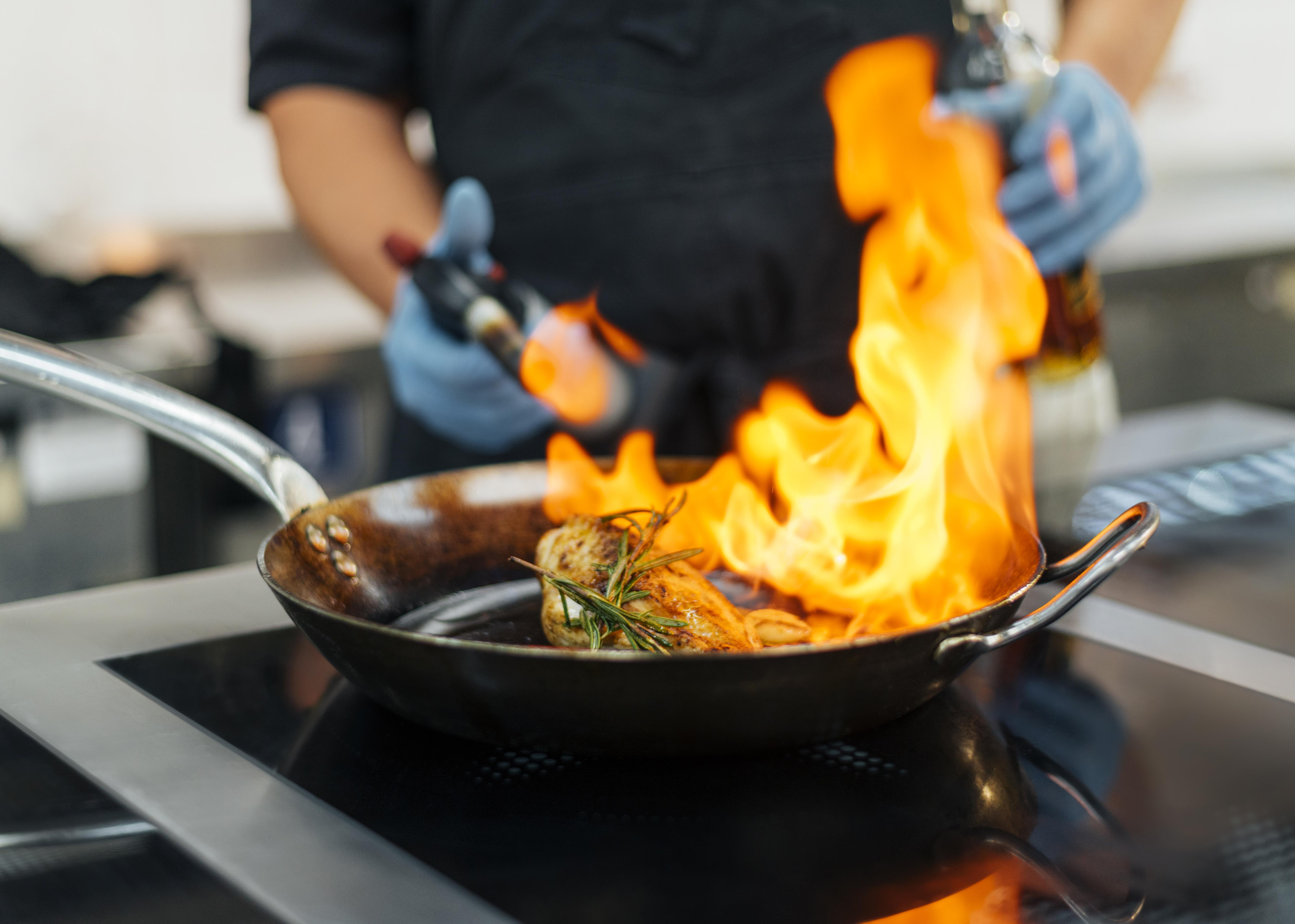 chef-with-gloves-flambeing-dish